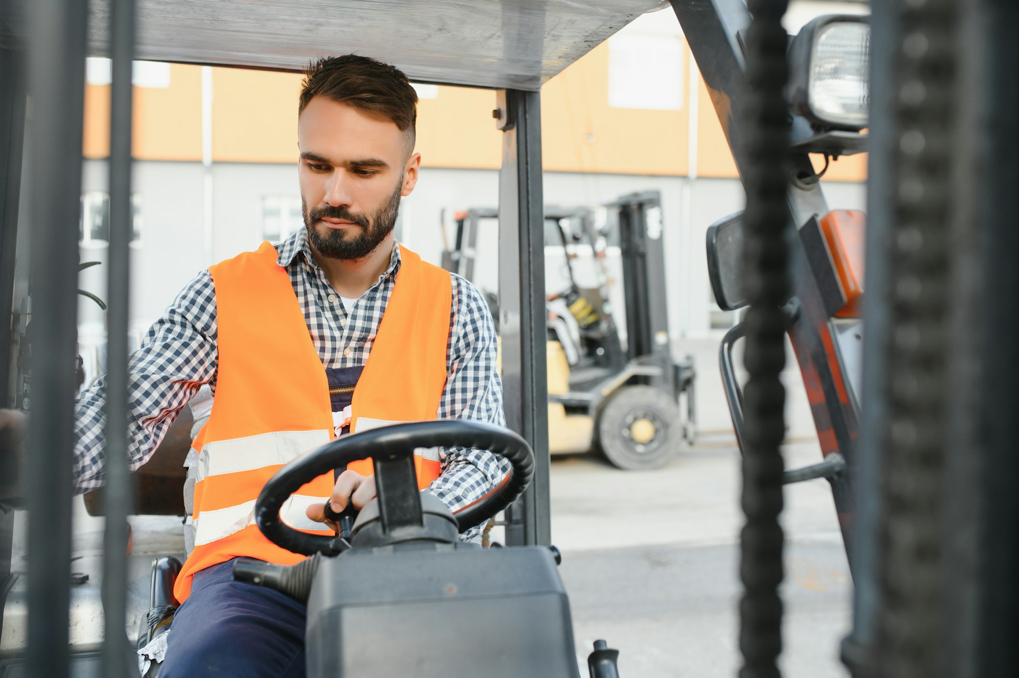 Waving forklift driver in the warehouse of a haulage company while driving forklift